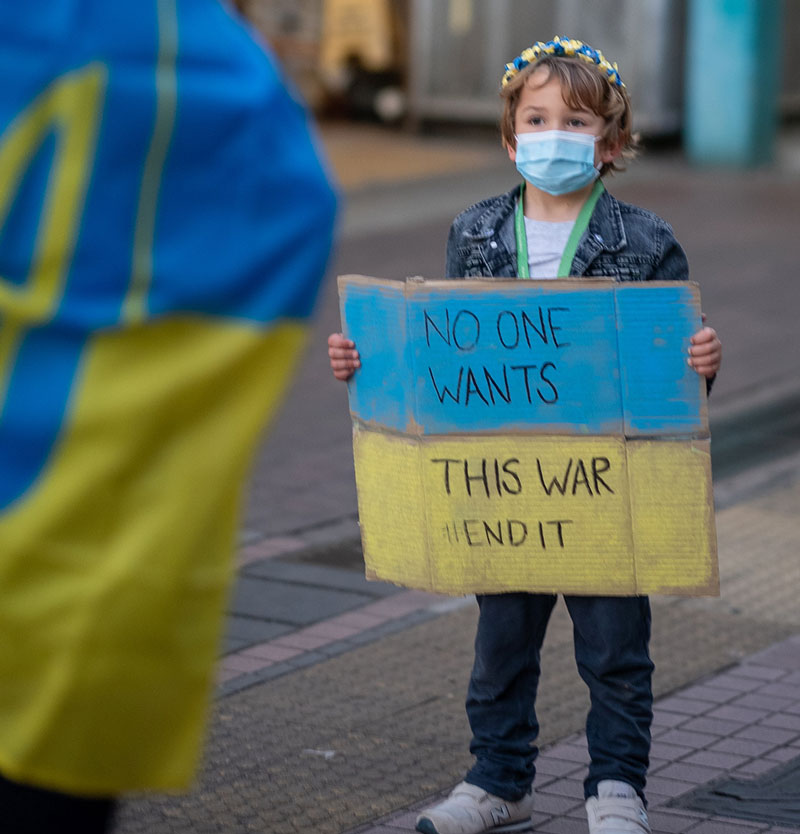 παιδί κρατάει στα χέρια του πινακίδα ενάντια στον πόλεμο στην Ουκρανία