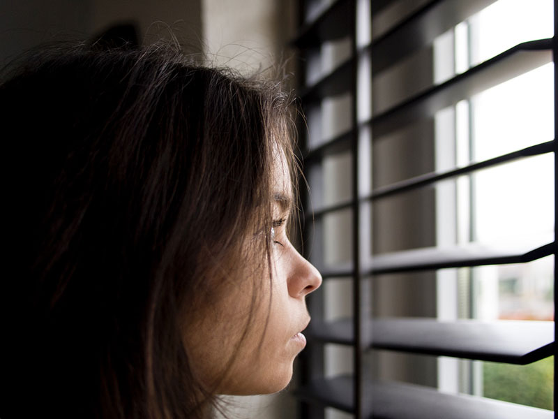 γυναίκα κοιτάζει έξω από το παράθυρο τις Περιβαλλοντικές – Ψυχολογικές Κρίσεις