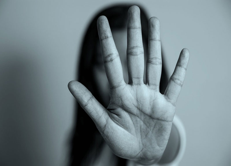 γυναίκα σηκώνει το χέρι της για τον κίνδυνο ορισμένων χρόνιων παθήσεων στα θύματα ενδοοικογενειακής βίας