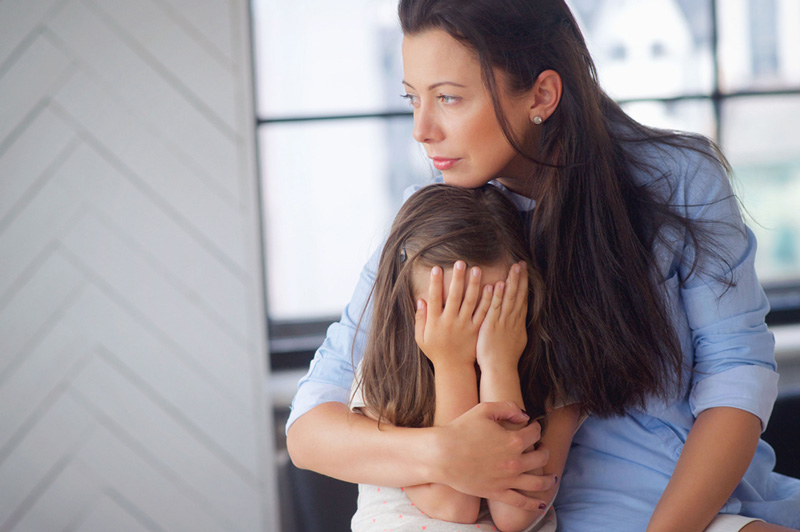 μητέρα με παιδικά τραύματα αγκαλιάζει το παιδί της