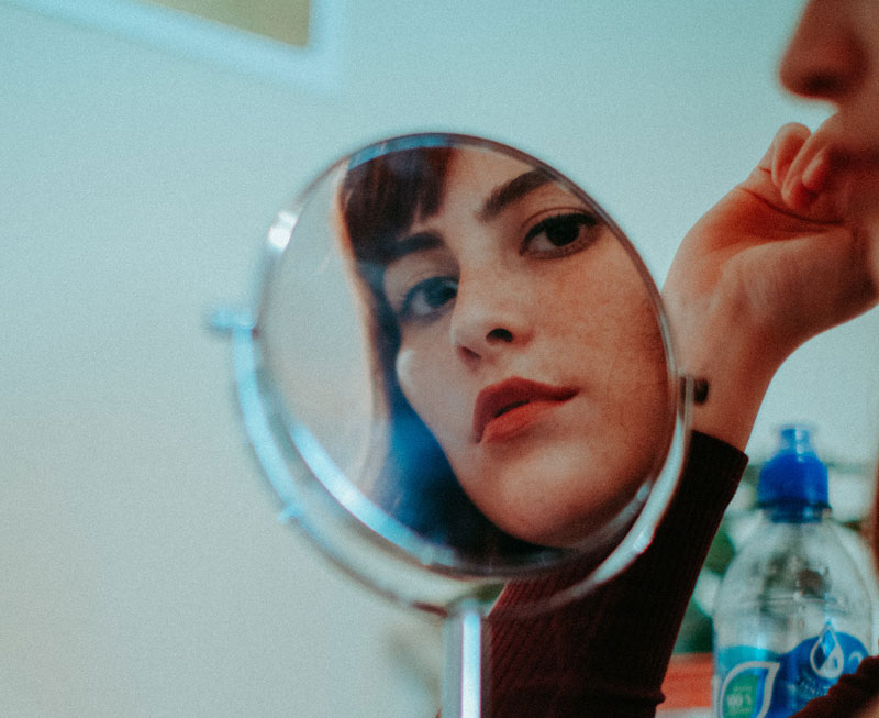 γυναίκα σταματάει να κοιτάζει τον εαυτό της στον καθρέφτη