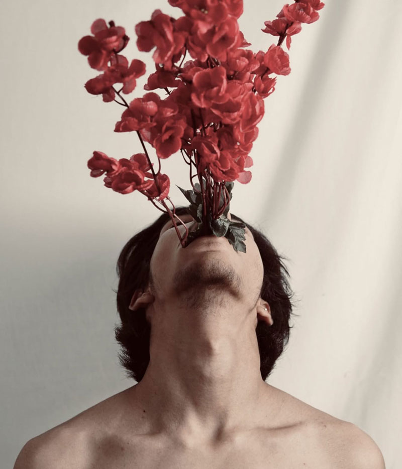 άνδρας με τριαντάφυλλα στο στόμα σκέφτεται την αρρενωπότητα