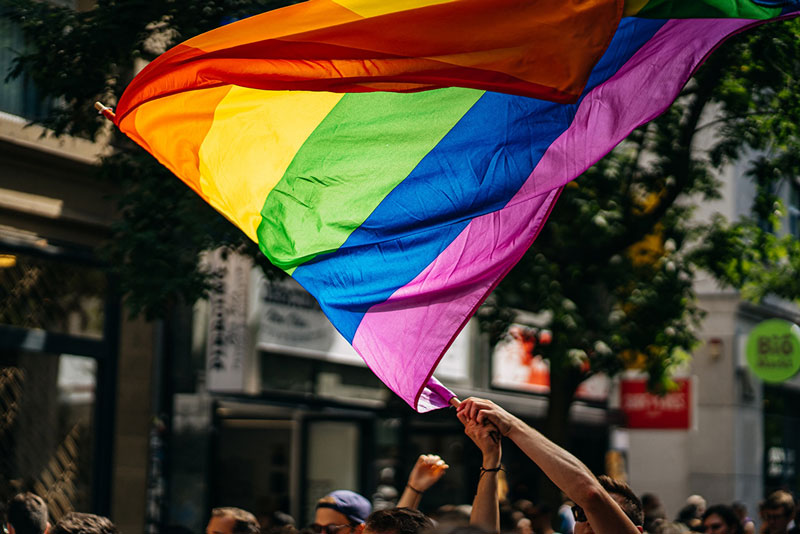 ομοφυλόφυλα άτομα κρατούν την σημαία της Ομοφυλοφιλικής Υπερηφάνειας