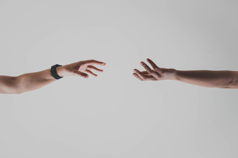 δύο ανθρώπινα χέρια που φτάνουν κοντά να συνδεθούν