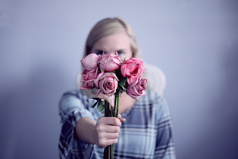 γυναίκα προσφέρει λουλούδια σε κάποιον που δεν εκτιμά όσα κάνει η ίδια