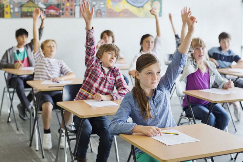 μαθητές σε τάξη σηκώνουν τα χέρια τους