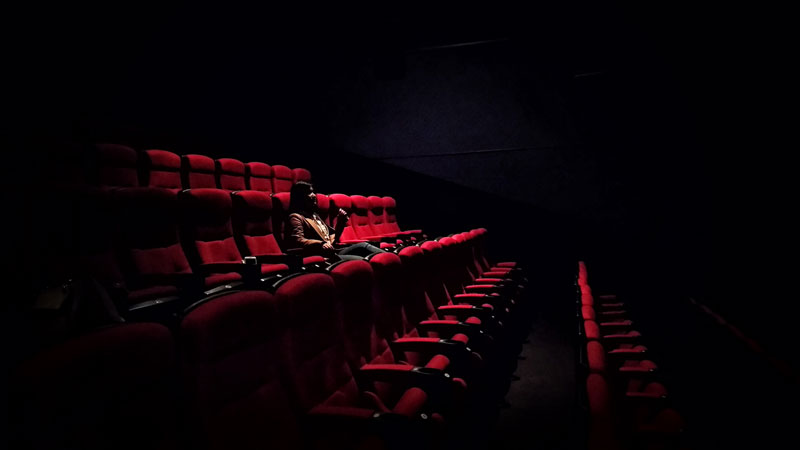 γυναίκα κάθεται σε μια αίθουσα κινηματογράφου