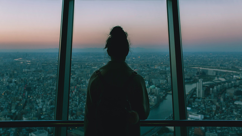 γυναίκα κοιτάζει έξω από το παράθυρο σε μια πόλη