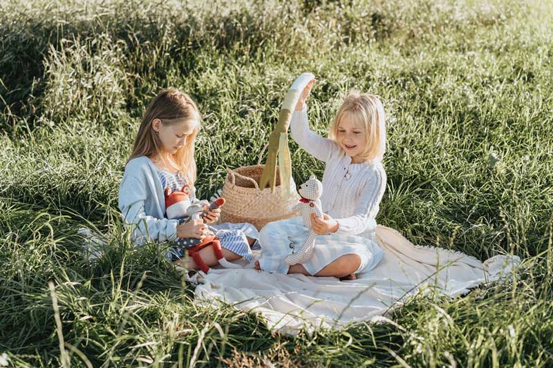 κορίτσια παίζουν με τις κούκλες τους σε ένα λιβάδι και αναπτύσσουν ενσυναίσθηση