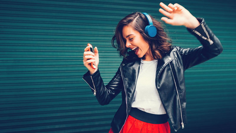 κοπέλα που χορεύει ακούγοντας τραγούδια που της ανεβάζουν την διάθεση σύμφωνα με επιστήμονες