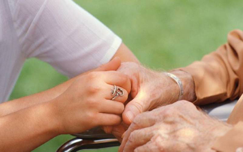 χέρια φροντιστή καθησυχάζουν ασθενή με Αλτσχάιμερ