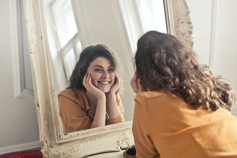 γυναίκα κοιτάζεται στον καθρέπτη και ανακαλύπτει την έννοια του ναρκισσισμού