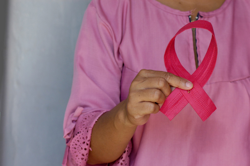 γυναίκα κρατά τη κορδέλα για την Παγκόσμια Ημέρα Πρόληψης κατά του Καρκίνου του Μαστού