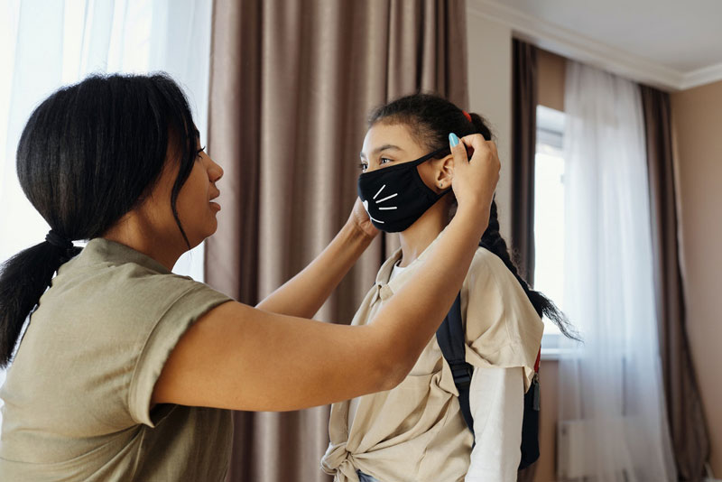 μητέρα φοράει τη μάσκα στη κόρη της για το άνοιγμα δημοτικών και νηπιαγωγείων που δεν αυξάνει τη θνητότητα από Covid-19
