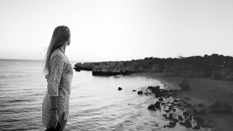 γυναίκα σε ασπρόμαυρη φωτογραφία κοιτάει προς την μια παραλία