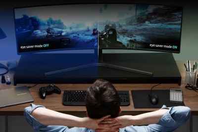 έφηβος κοιτάζει σε μία μεγάλη οθόνη ένα βιντεοπαιχνίδι με τα χέρια πίσω στο κεφάλι