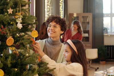 οικογένεια στολίζει το χριστουγεννιάτικο δέντρο στο σπίτι τους
