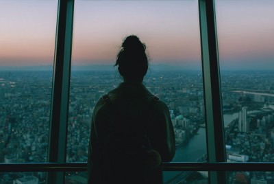 γυναίκα κοιτάζει έξω από το παράθυρο σε μια πόλη
