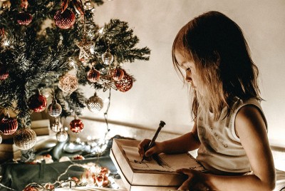 παιδί που γράφει γράμμα στον Άγιο Βασίλη και αναρωτιέται αν έρχεται