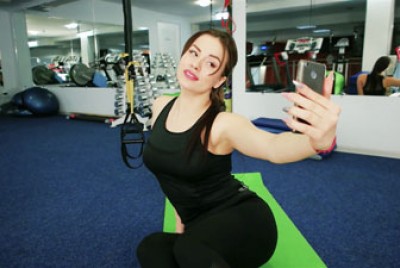 γυναίκα που τραβάει selfie στο γυμναστήριο χαμογελώντας