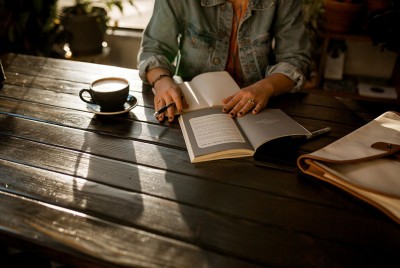 γυναίκα διαβάζει βιβλίο στο σπίτι της εξαιτίας της αυτοαπομόνωσης