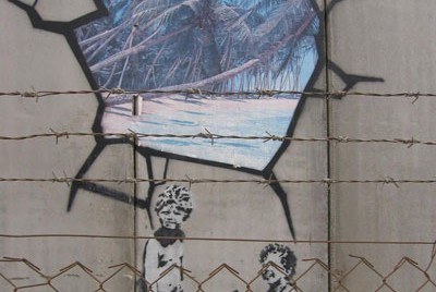 γκραφίτι που απεικονίζει δυο παιδιά να έχουν ζωγραφίσει μια εξωτική παραλία