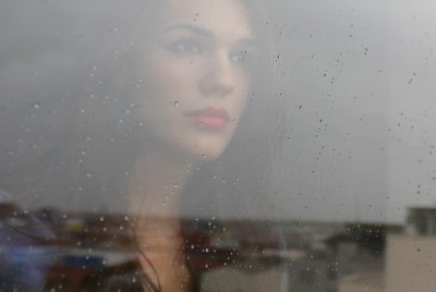 γυναίκα κοιτάζει πίσω από ένα παράθυρο έξω στη πόλη