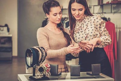 μια υπάλληλος βοηθά μια γυναίκα να αγοράσει κοσμήματα