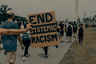 άνθρωποι σε πορεία ενάντια στον ρατσισμό που τροφοδοτεί την κακή ψυχική και σωματική υγεία