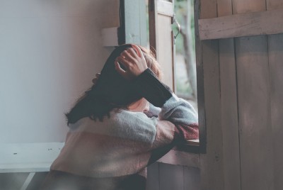 γυναίκα καθισμένη μπροστά από ένα παράθυρο θέλει ψυχική υγεία