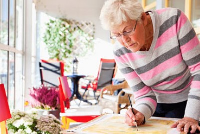 ηλικωμένη γυναίκα ζωγραφίζει στο σπίτι της