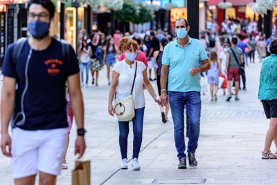 άνθρωποι περπατούν σε δρόμο φορώντας μάσκες λόγω πανδημίας