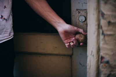 ανδρικό χέρι που πιάνει το πόμολο μιας παλιάς πόρτας