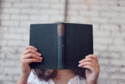 κοπέλα κρατά βιβλίο έχοντας κάνει λάθη γνωσιακά που μπορούν να βλάψουν την ψυχική της ανθεκτικότητα
