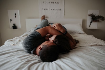 ένα ζευγάρι είναι αγκαλιά στο κρεββάτι