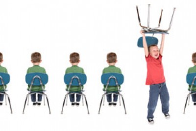 ένα παιδί σηκώνει στα χέρια την καρέκλα του