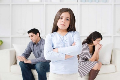 κορίτσι που στέκεται θυμωμένο μπροστά από τους γονείς που κάθονται σε καναπέ