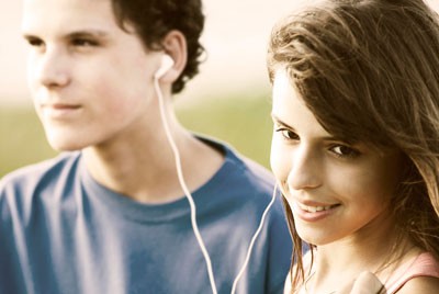 αγόρι και κορίτσι στην εφηβεία ακούν μαζί ένα τραγούδι από ακουστικά