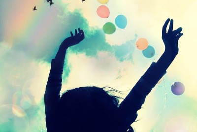 σιλουέτα γυναίκας με τα χέρια ψηλά και μπαλόνια στον αέρα