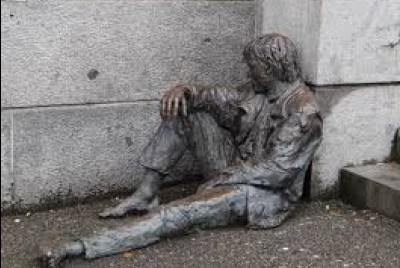 άγαλμα άνδρα καθισμένου κάτω με την πλάτη στον τοίχο