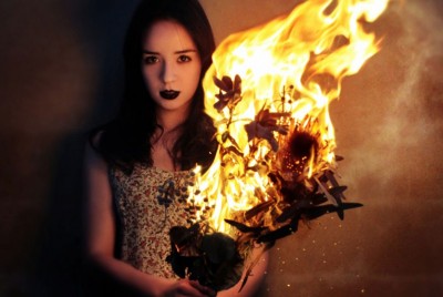 γυναίκα κρατάει ανθοδέσμη που έχει πιάσει φωτιά