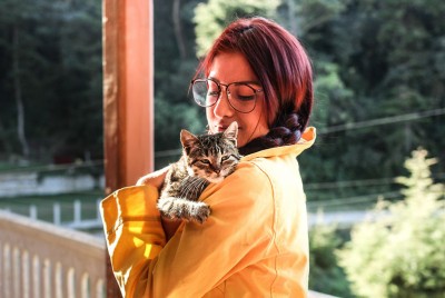 γυναίκα κρατάει στην αγκαλιά μια γάτα με τοξόπλασμα που σχετίζεται με τον κίνδυνο εκδήλωσης ψύχωσης