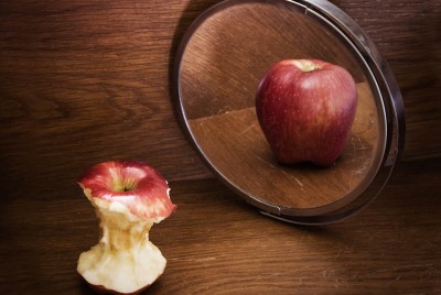 ένα φαγωμένο μήλο που όμως στον καθρέπτη φαίνεται άθικτο