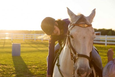 μια ιππέας πάνω σε άλογο σε μια φάρμα