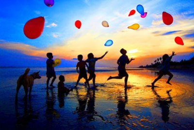 παιδιά που παίζουν με μπαλόνια στην παραλία