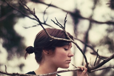 γυναίκα σε ένα δάσος ακουμπάει σε κλαδιά