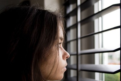 γυναίκα κοιτάζει έξω από το παράθυρο τις Περιβαλλοντικές – Ψυχολογικές Κρίσεις