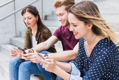 νέοι άνθρωποι χρησιμοποιούν social media στο κινητό τους