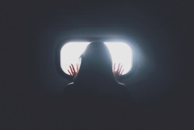γυναίκα με διαταραχή άγχους κοιτάζει από ένα παράθυρο