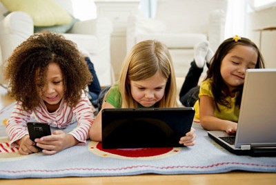 3 κοριτσάκια μπροστά από διάφορες ηλεκτρονικές συσκευές
